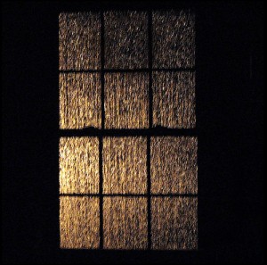 12 paned window; lit up at night by lightning; rain streaming down the panes